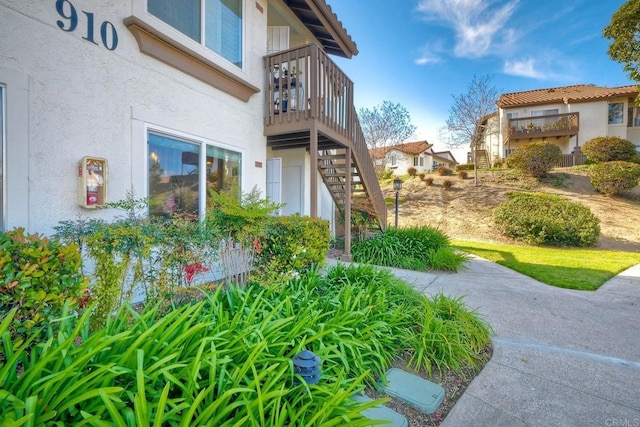 exterior space featuring stairway and stucco siding