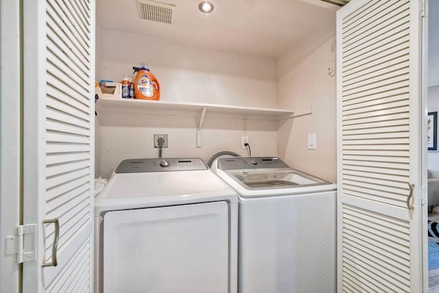 washroom featuring visible vents, separate washer and dryer, and laundry area