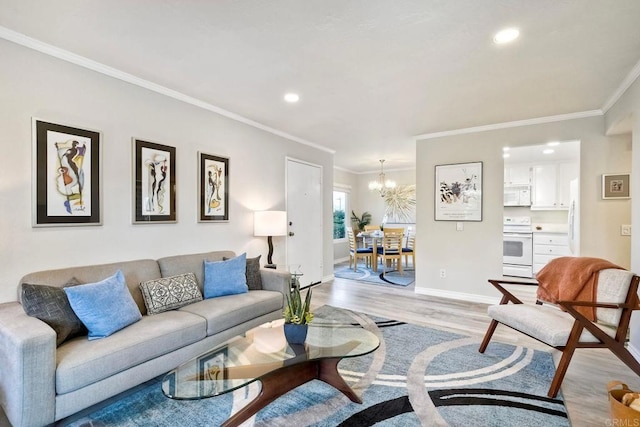 living area featuring baseboards, ornamental molding, recessed lighting, an inviting chandelier, and light wood-style floors