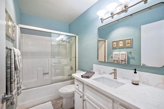 full bathroom featuring bath / shower combo with glass door, toilet, wood finished floors, and vanity