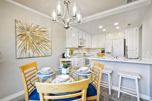 dining space with crown molding, visible vents, dark wood-style flooring, and a chandelier