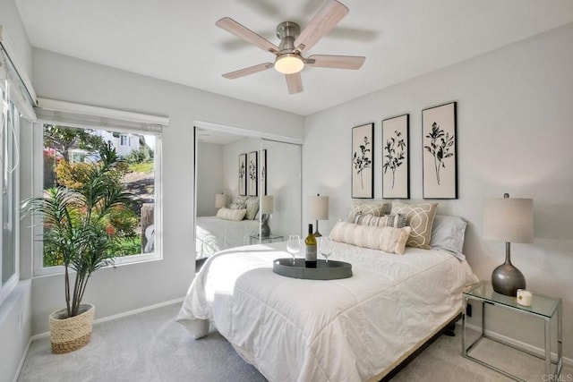 carpeted bedroom with a closet, ceiling fan, and baseboards