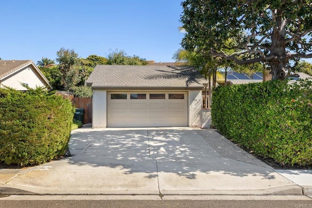 garage with driveway and fence