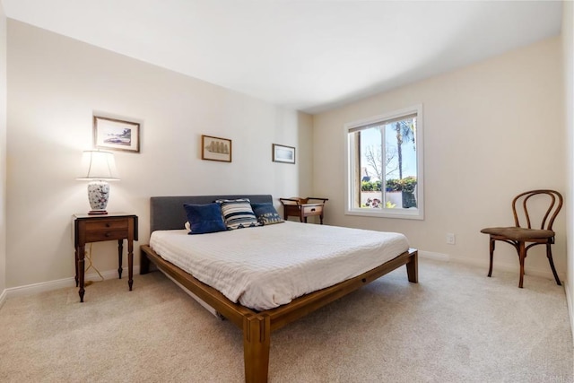 bedroom featuring baseboards and light carpet