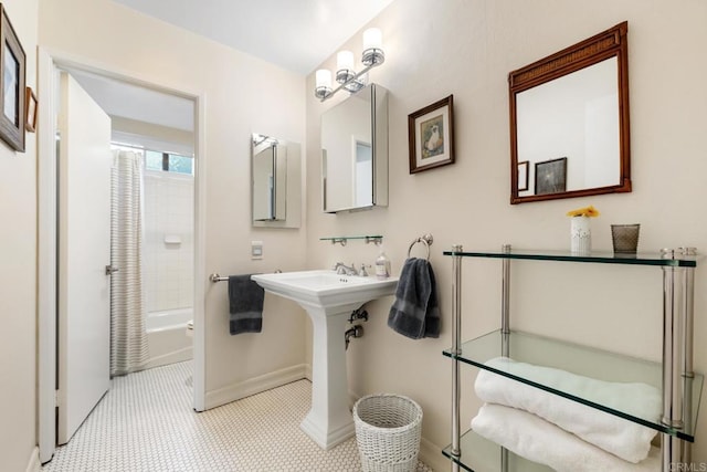 bathroom with bathing tub / shower combination and baseboards