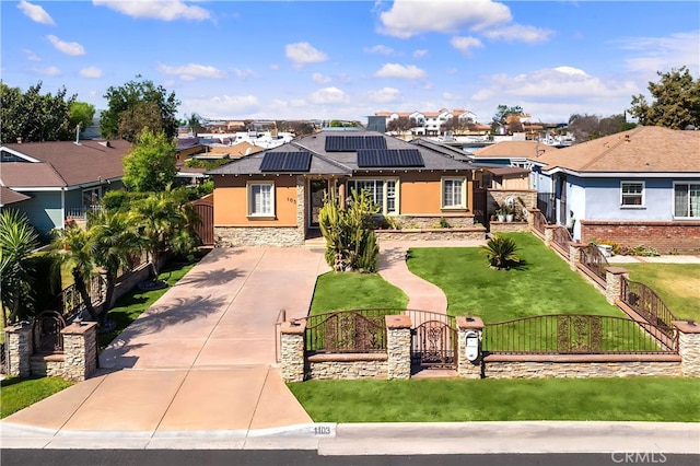 view of front facade with a gate, solar panels, stucco siding, stone siding, and a fenced front yard