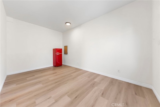 spare room featuring light wood-style flooring and baseboards