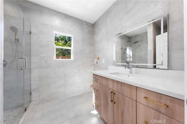 bathroom with vanity, tile walls, and a shower stall