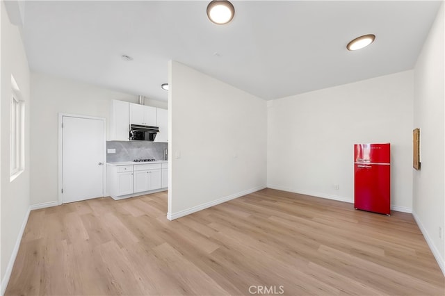 empty room with light wood finished floors and baseboards