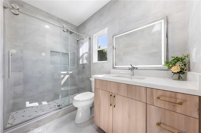 full bathroom featuring vanity, tile walls, toilet, and a stall shower