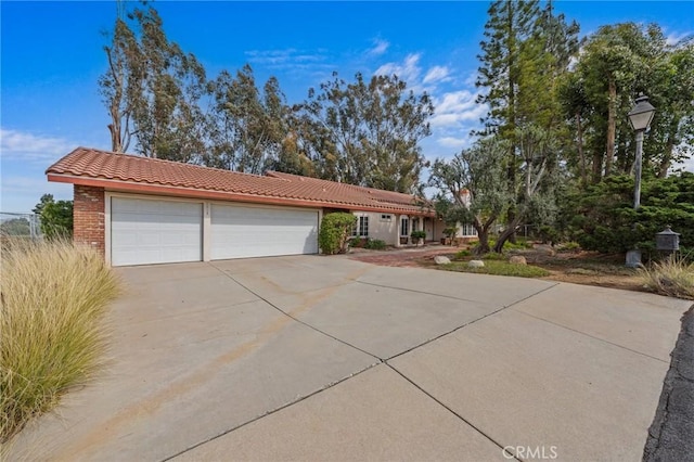 view of front of house featuring stucco siding, driveway, an attached garage, and a tile roof