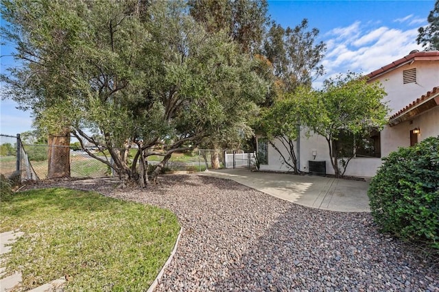 view of yard featuring cooling unit, a patio area, and fence