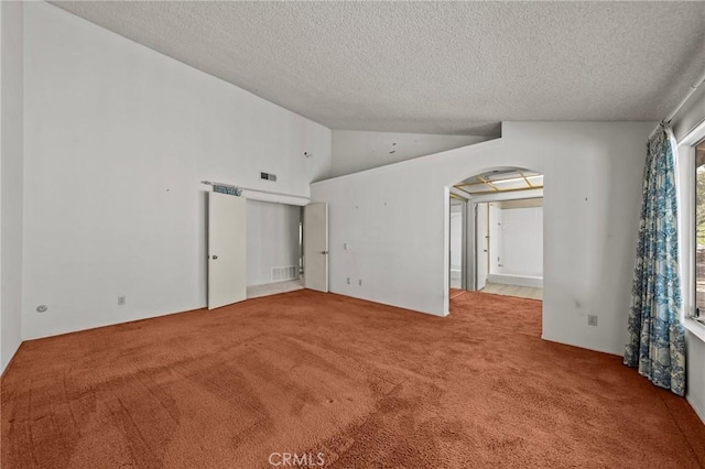 spare room featuring arched walkways, visible vents, lofted ceiling, and carpet floors