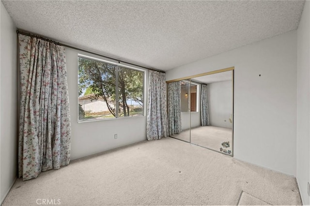 unfurnished bedroom with a closet, carpet, and a textured ceiling