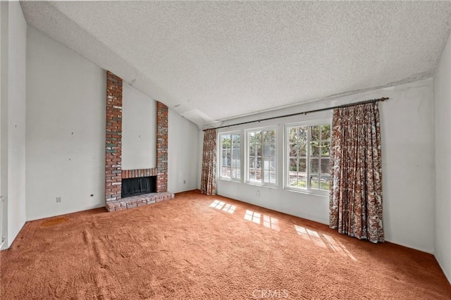 unfurnished living room with a textured ceiling, carpet, a brick fireplace, and vaulted ceiling