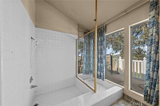 full bath featuring a tile shower and vaulted ceiling