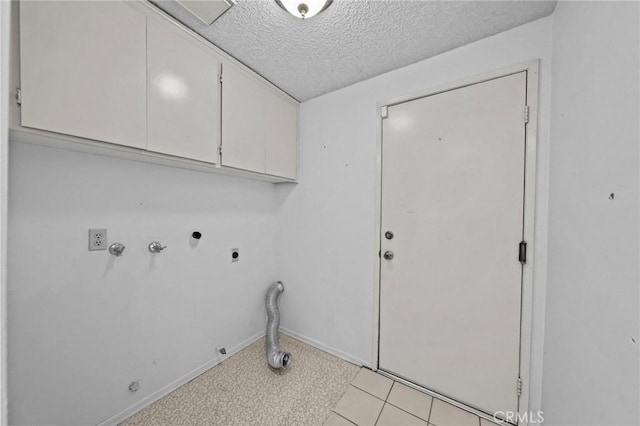 clothes washing area featuring hookup for a washing machine, cabinet space, electric dryer hookup, a textured ceiling, and hookup for a gas dryer