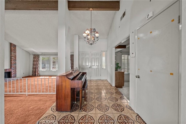 foyer entrance with light carpet, visible vents, beamed ceiling, and a textured ceiling