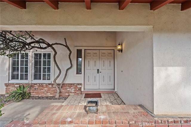 entrance to property with brick siding and stucco siding