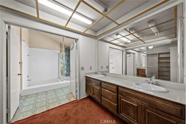 full bath featuring a shower with shower curtain, double vanity, and a sink