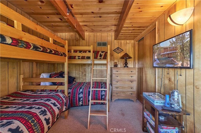 carpeted bedroom featuring wood ceiling, wooden walls, beamed ceiling, and visible vents