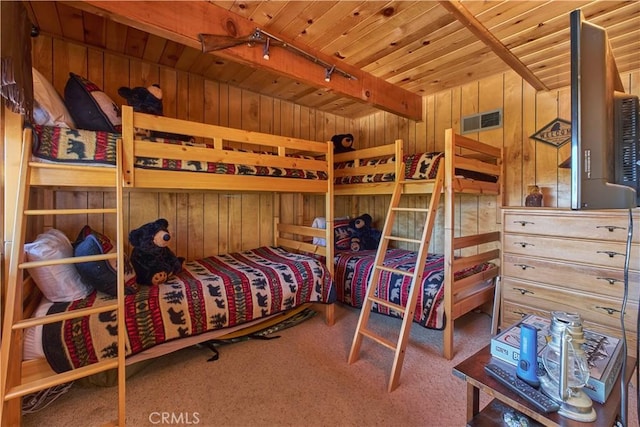 bedroom featuring wood ceiling, rail lighting, carpet floors, and wooden walls