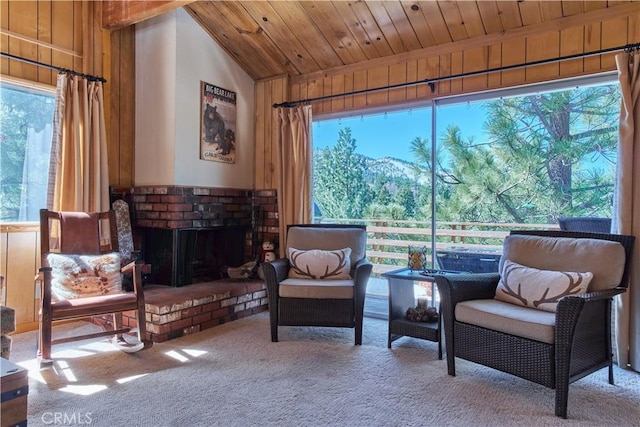 carpeted living area with lofted ceiling, a healthy amount of sunlight, wooden ceiling, and a fireplace