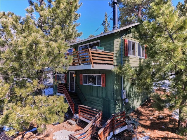 view of front of property with a balcony, stairs, and board and batten siding