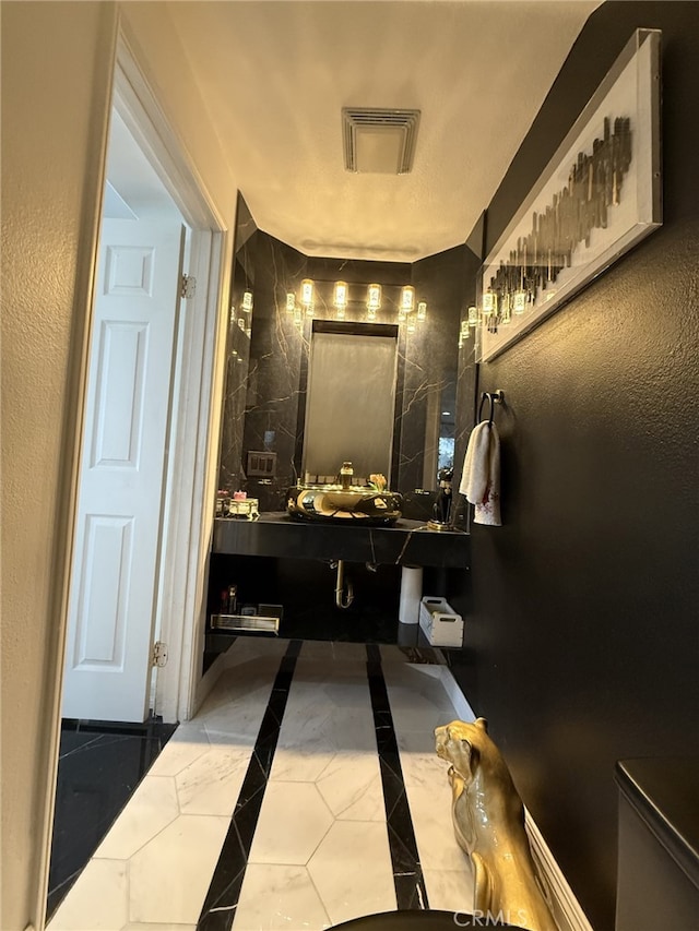 bathroom with visible vents and a textured wall