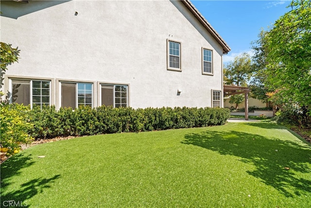 view of home's exterior with a tile roof, stucco siding, a pergola, and a lawn