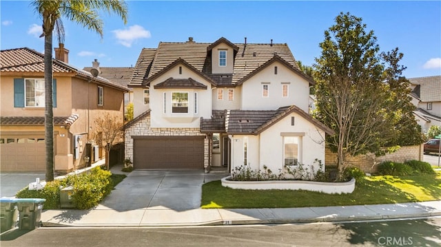 view of front of property featuring stucco siding, concrete driveway, a garage, stone siding, and a tiled roof