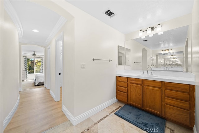 bathroom featuring visible vents, connected bathroom, crown molding, baseboards, and vanity