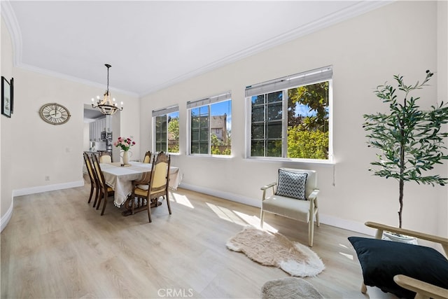 dining area with crown molding, a notable chandelier, baseboards, and light wood-type flooring