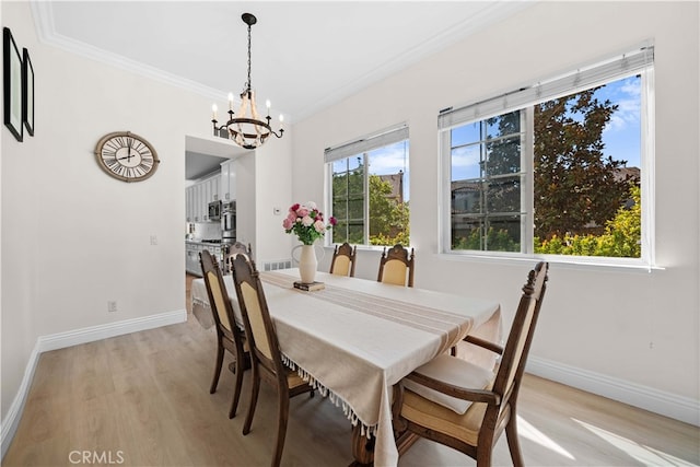 dining area featuring light wood-type flooring, baseboards, and ornamental molding