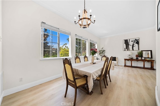 dining room with a notable chandelier, light wood-style floors, baseboards, and ornamental molding