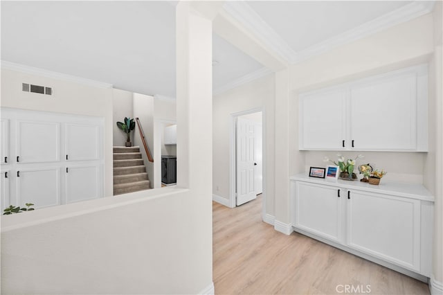 hall with visible vents, stairway, crown molding, light wood finished floors, and baseboards