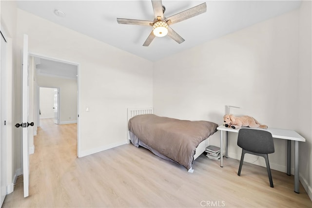 bedroom with a ceiling fan, wood finished floors, and baseboards