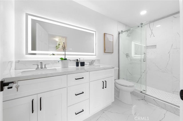 bathroom with a marble finish shower, toilet, double vanity, marble finish floor, and a sink