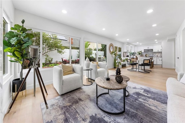 living area with recessed lighting and light wood-style flooring