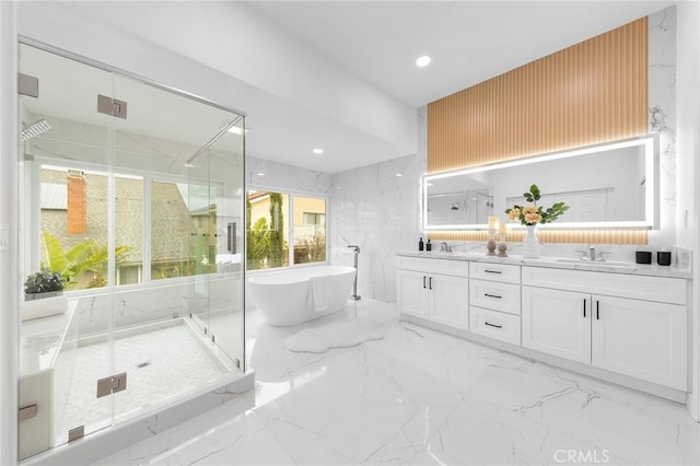 bathroom featuring a marble finish shower, marble finish floor, stone wall, and a sink