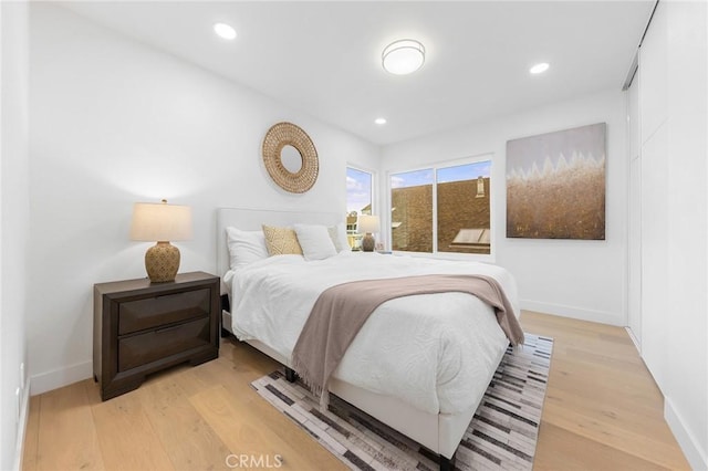 bedroom with recessed lighting, light wood-style floors, and baseboards