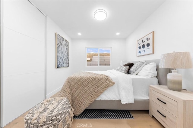 bedroom with recessed lighting and light wood-style flooring