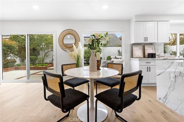 dining room featuring light wood-style flooring, plenty of natural light, and recessed lighting