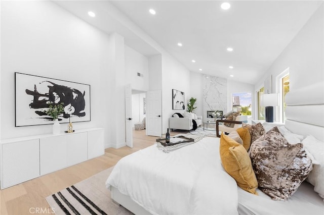 bedroom with recessed lighting, light wood-style flooring, high vaulted ceiling, and visible vents