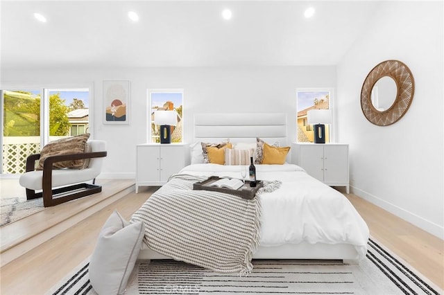 bedroom with recessed lighting, wood finished floors, and baseboards