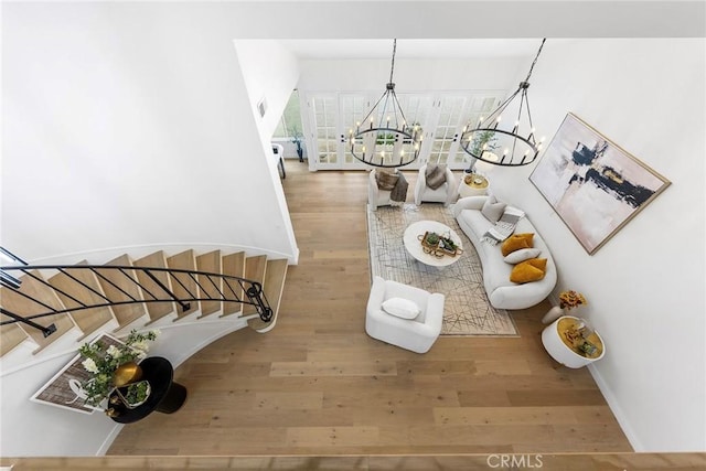 staircase with baseboards, an inviting chandelier, and wood finished floors