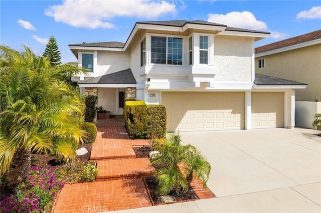 view of front of property with a garage, driveway, and stucco siding