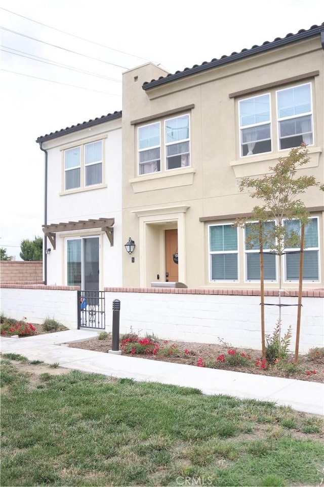 townhome / multi-family property featuring a fenced front yard and stucco siding