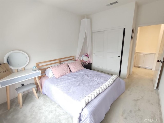 bedroom featuring a closet, visible vents, and light colored carpet