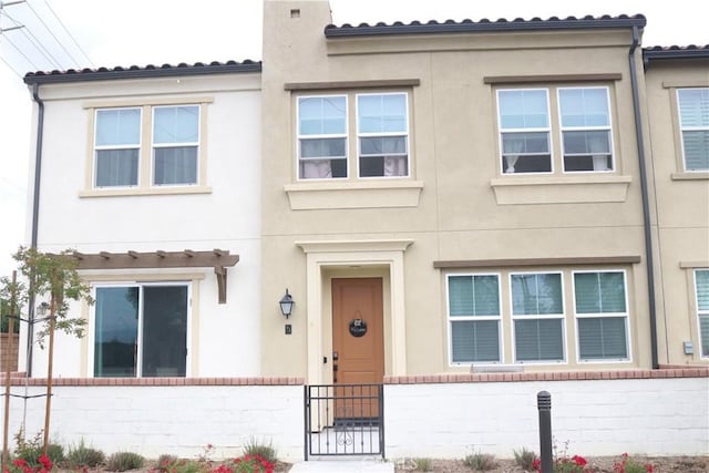 view of front of home with stucco siding and fence